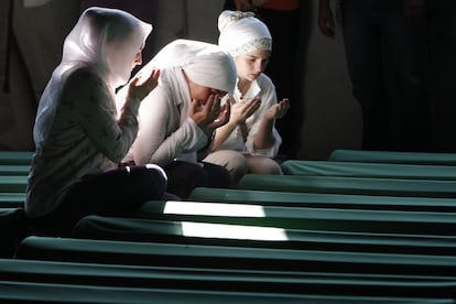 Mujeres bosnias musulmanas rezan junto al ataúd de un pariente, una de las 520 nuevas víctimas identificadas de Srebrenica, en el cementerio conmemorativo de Potocari, en julio de 2012.