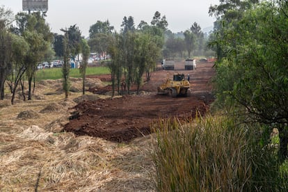 Una aplanadora cubre con piedra la parte del humedal donde se instalará el puente.