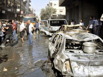 Varios vecinos inspeccionan los da&ntilde;os tras una explosi&oacute;n, en Damasco.
