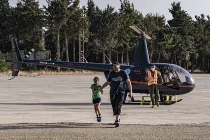 Entre el grupo de turistasm saliendo del helicóptero R44 después de la excursión de 15 minutos alrededor de la Base Aérea de Rayak, una niña salta con entusiasmo. 