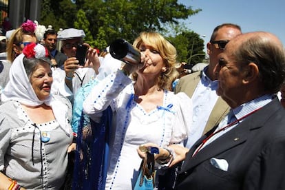 Esperanza Aguirre bebe un trago de agua del santo vestida de chulapa.