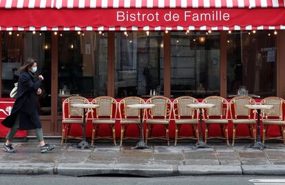 Una mujer pasa por delante de un restaurante en París, antes de que las autoridades parisinas anuncien nuevas restricciones debido al aumento del número de contagios en la capital francesa. 