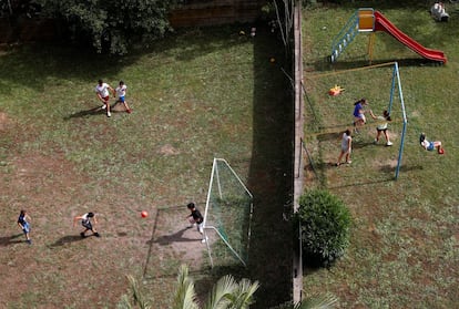 Vista aérea de unos niños jugando al fútbol mientras unas niñas juegan en los columpios, en Roma (Italia)