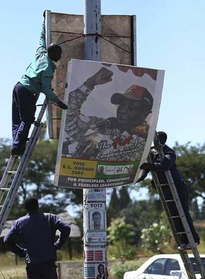 Retirada de carteles electorales de Mugabe, ayer en Harare.