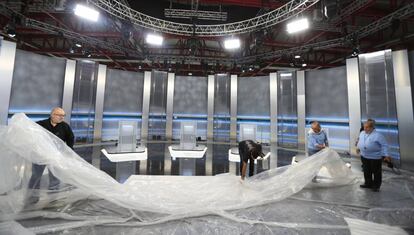 Unos operarios preparan el plató del debate en el Pabellón de Cristal de la Casa de Campo.