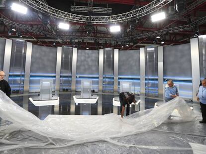 Unos operarios preparan el plató del debate en el Pabellón de Cristal de la Casa de Campo.