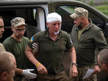 Ukrainian soldiers help their wounded fellow at a medical stabilisation point near Bakhmut, Donetsk region, Ukraine, Wednesday, May 24, 2023.