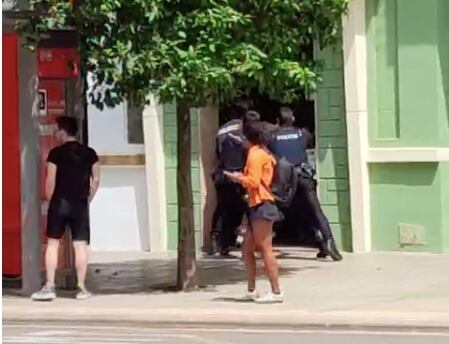 Varios agentes de la Policía Nacional empujan a un hombre al interior de un portal durante una intervención este sábado en Valencia.
