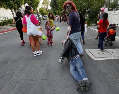 Un hombre con una máscara tira de una figura de peluche que representa a los cientos de víctimas de ejecuciones extrajudiciales en la "guerra contra las drogas", en Makati, al sureste de Manila (Filipinas), el 31 de octubre.