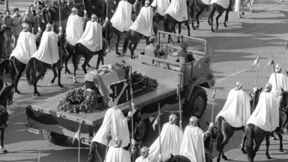 Traslado del cortejo con los restos mortales de Franco al Valle de los Caídos cubierto con una bandera del Águila de San Juan.