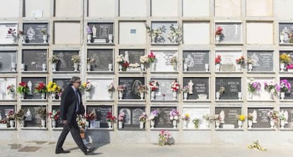 Martín Zamora, en el cementerio ceutí, camina junto a una galería de nichos con varias tumbas sin lápida donde reposan los cuerpos de inmigrantes.
