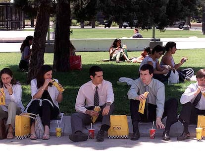 Un grupo de ejecutivos consumen en la calle productos de Pans & Company.