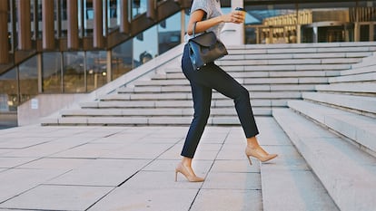 Una mujer subiendo las escaleras con zapatos de tacon.