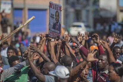 Los simpatizantes del partido MDC de la oposición, sostienen una pancarta de votación en una calle de Harare, durante enfrentamientos con la policía el miércoles 1 de agosto de 2018. 