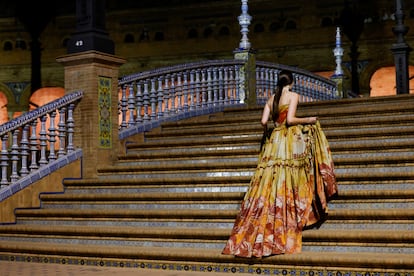 Una modelo sube las escaleras de la plaza de España de la localidad hispalense durante el desfile.