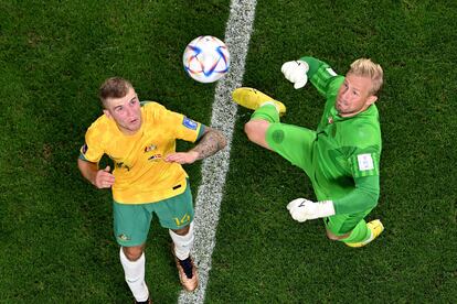 Kasper Schmeichel (derecha) trata de despejar un balón con el puño frente al mediocentro australiano  Riley McGree.