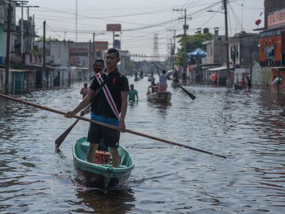 Los residentes locales usan botes en una calle inundada después de las fuertes lluvias en Villahermosa, Tabasco.