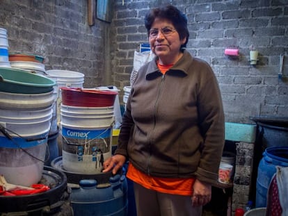 Una mujer con los cubos que usa para recoger agua de lluvia.