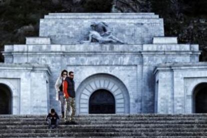 Una familia realizando una visita tur&iacute;stica en la explanada bajo la cruz del Valle de los Ca&iacute;dos.