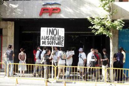 Un grupo de manifestantes ayer por la tarde frente a la sede del Partido Popular en Madrid.