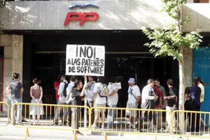 Un grupo de manifestantes ayer por la tarde frente a la sede del Partido Popular en Madrid.