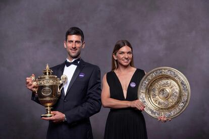 El campeón de individuales de Wimbledon masculino Novak Djokovic de Serbia (izquierda) y la campeona de individuales de Wimbledon Femenino Simona Halep de Rumania (derecha), sostienen sus trofeos durante la Cena de Campeones del torneo británico.