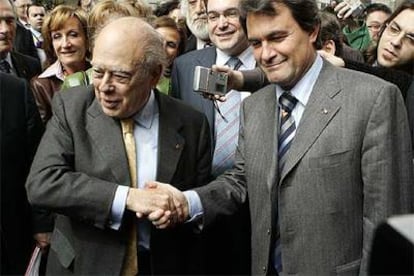 Jordi Pujol (izquierda) y Artur Mas se saludan tras la aprobación del Estatuto en el Congreso.