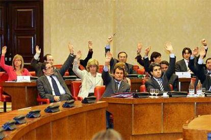 Los parlamentarios autonmicos catalanes de CiU, en primera fila, y del PCS, votan a favor de la reforma del Estatuto.