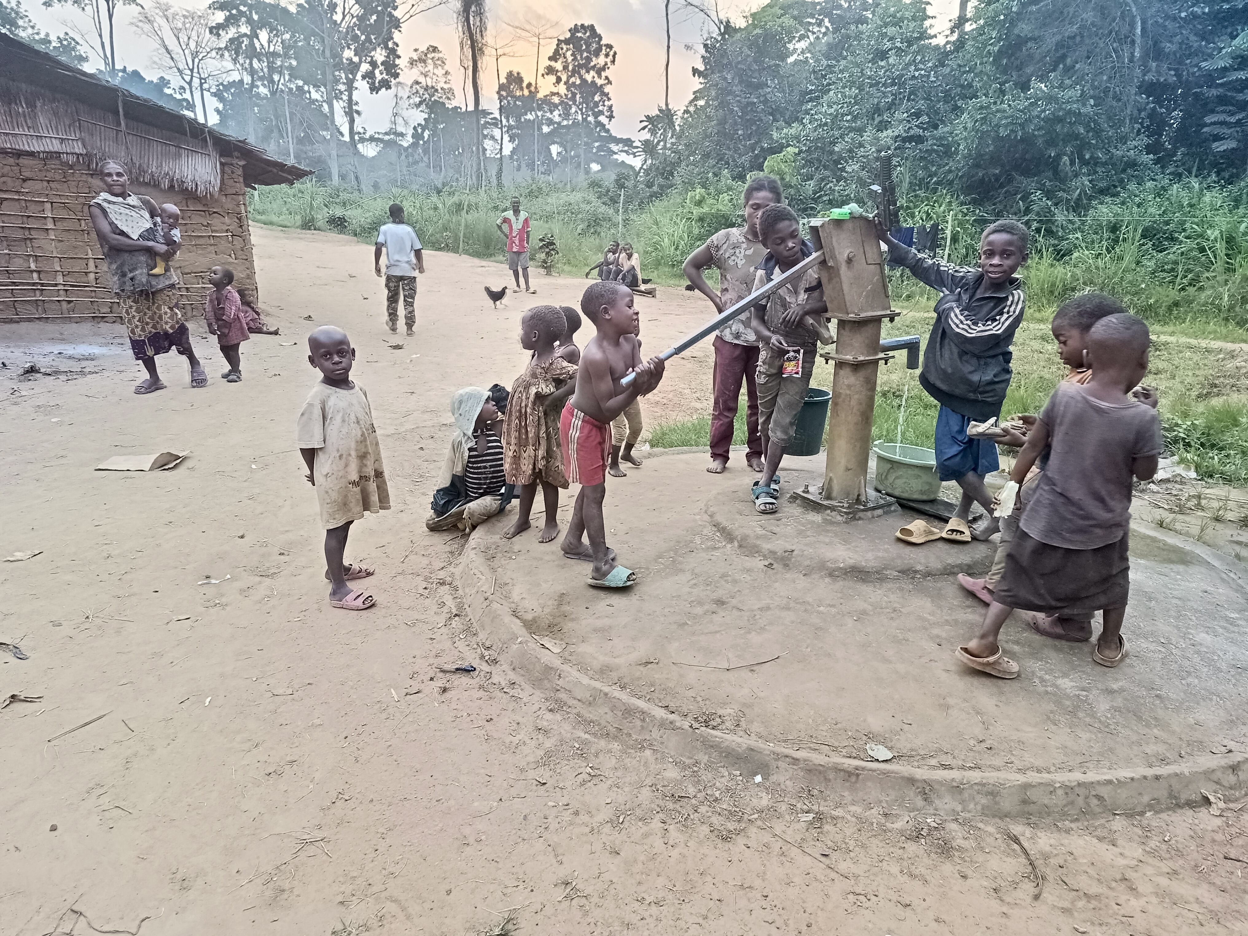 Varios niños baka de la aldea Mimbil, en el sur de Camerún, alrededor de una fuente de agua, el 16 de enero de 2026.