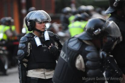 Un agente de policía sostiene varios botes de gas lacrimógeno supuestamente utilizados para dispersar las protestas en Venzuela.