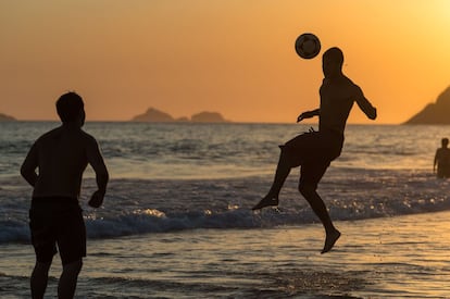 Dos jóvenes juegan al fútbol en Ipanema en enero.