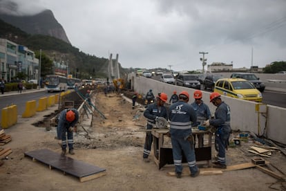 Obreros trabajando sin parar en medio del tráfico de Barra da Tijuca.