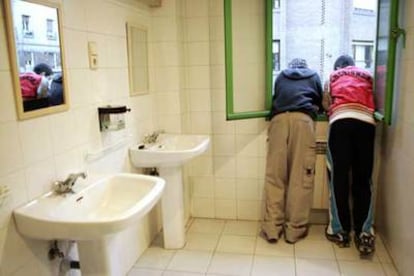 Dos adolescentes, en los lavabos del centro al que asisten a una terapia de ayuda contra el consumo de <i>hachís.</i>