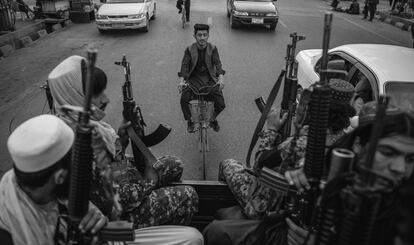 Un ciclista viaja detrás de una patrulla talibán en septiembre de 2021 por las calles de Kabul. 