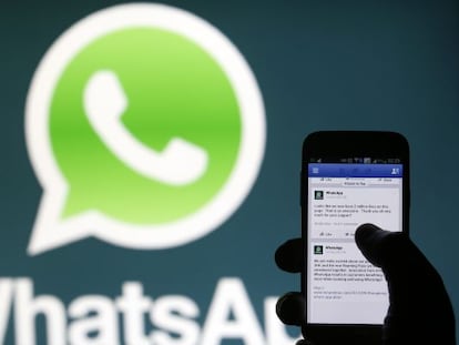 Un usuario de móvil frente al logo de WhatsApp