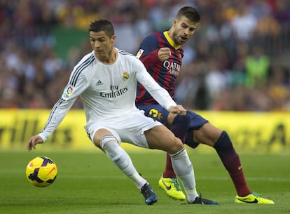 El delantero Cristiano Ronaldo lucha por un balón con Gerard Piqué.