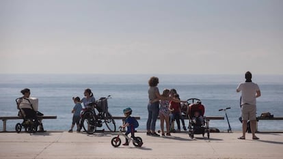 Families enjoy the seaside promenade in Barcelona on Sunday.