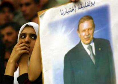 Una joven  argelina, junto a un cartel electoral del presidente Abdelaziz Buteflika, ayer durante un mitin en Argel.