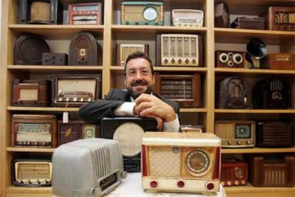 Miguel Carballeda, con parte de su colección de 400 radios antiguas.