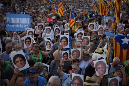 Manifestantes sostienen caretas con la imagen de Carles Puigdemont durante la concentración convocada para recibir al expresidente de la Generalitat en el paseo en el Lluís Companys de Barcelona.