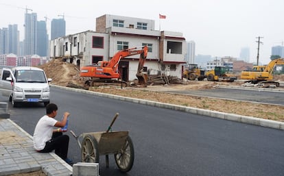 Uma casa de três andares se encontra na rua central do distrito de Luolong, o que obriga à interrupção da construção de uma estrada, em 16 de maio de 2015, na província de Henan, China