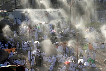Peregrinos musulmanes rociados con agua en la llanura de Arafat durante la peregrinación anual del Haj.