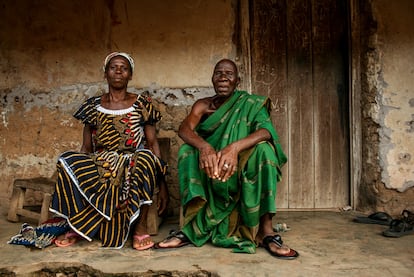 Abran Siman Marie y su hermano Essi Kouakou posan frente a su vieja casa de adobe.