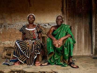 Abran Siman Marie y su hermano Essi Kouakou posan frente a su vieja casa de adobe.