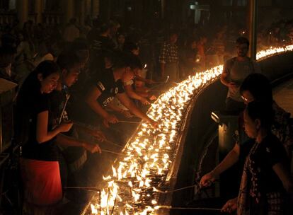 Un grupo de voluntarios encienden lámparas de aceite durante la celebración de la Hora del Planeta en Shwedagon (Myanmar).