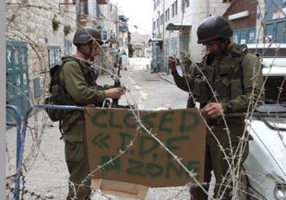 Soldados israelíes colocan un cartel en Belén en el que se lee 'Zona cerrada por las Fuerzas de Defensa Israelies'.