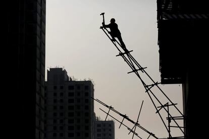 La silueta de un trabajador sobre un andamio para encofrado se perfila entre varios los edificios en construcción, en Pekín. El PIB de China aumentó un 7,4% en 2014, el incremento más bajo desde 1990, según los datos oficiales divulgados por el Gobierno chino, cuyas previsiones situaban la cifra en el 7,5%.