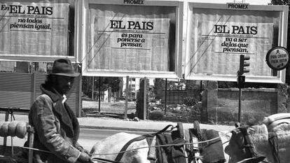 Un hombre pasa por delante de varios carteles de publicidad de EL PAÍS, en 1976.
