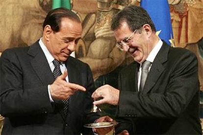 Prodi y Berlusconi bromean con una campanilla durante el cambio de Gobierno el pasado mayo.