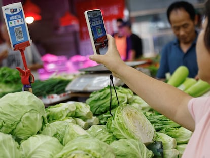 Una clienta escanea un código QR para pagar en un mercado de Pekín, China.